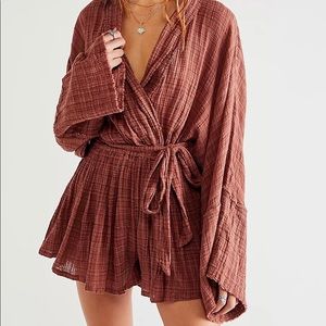 Romper is featured in a wrap silhouette with exaggerated sleeves, flouncy short